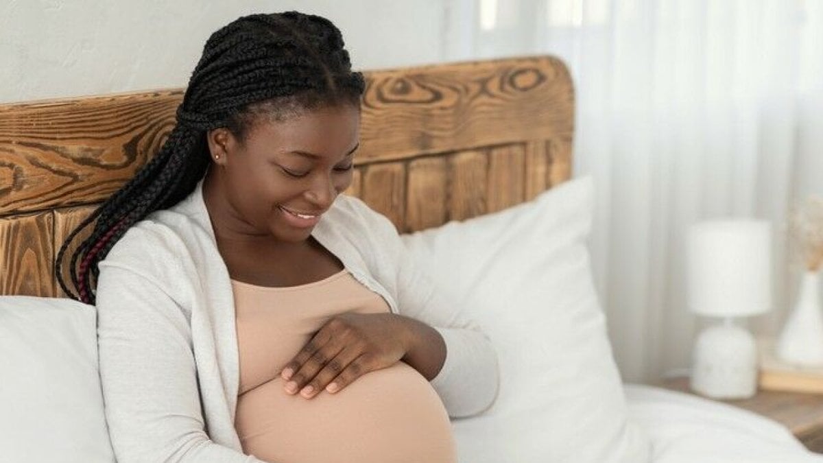 Gravid kvinna klappar sin mage